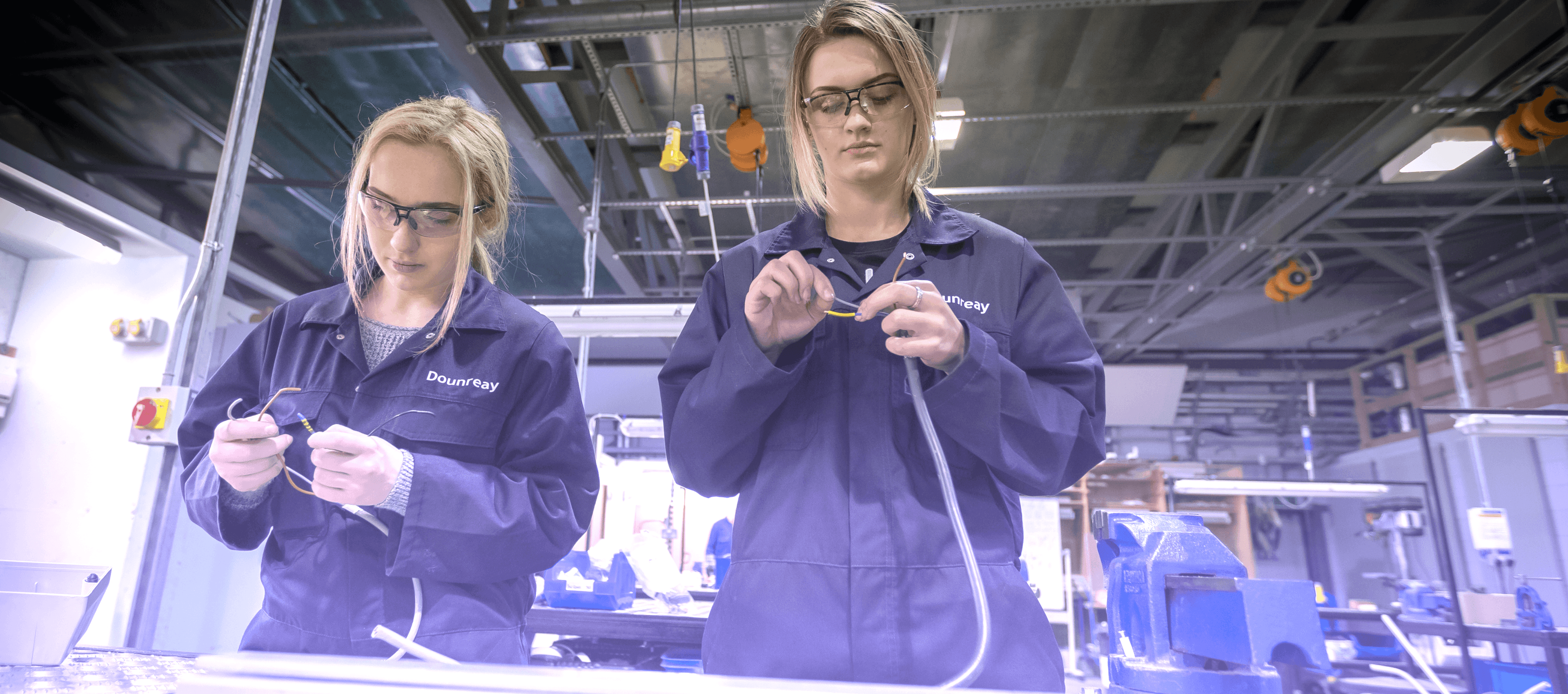 Factory workers in blue jumpsuit and safety goggles